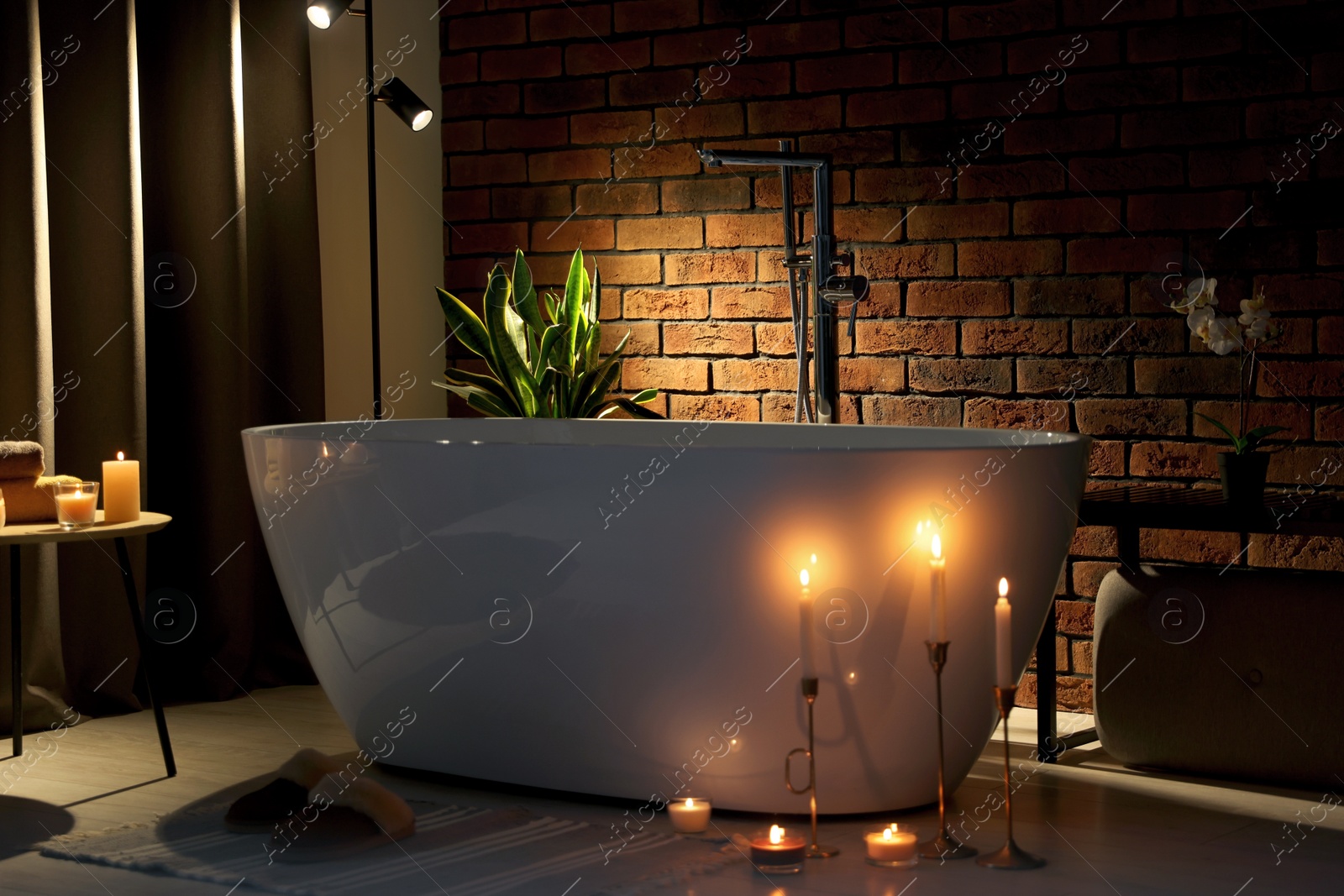 Photo of Stylish bathroom interior with ceramic tub and burning candles