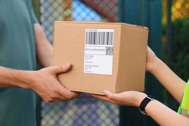Photo of Man receiving parcel from courier outdoors, closeup