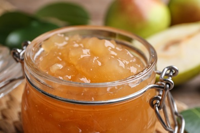 Photo of Delicious pear jam in glass jar, closeup