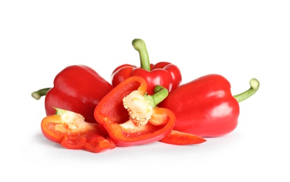 Cut and whole ripe red bell peppers on white background