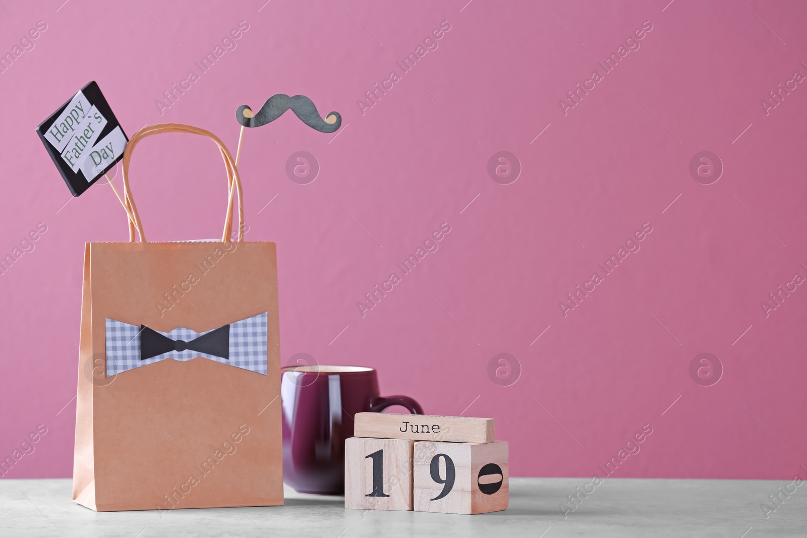 Photo of Calendar with date and gift bag on table. Father's day celebration