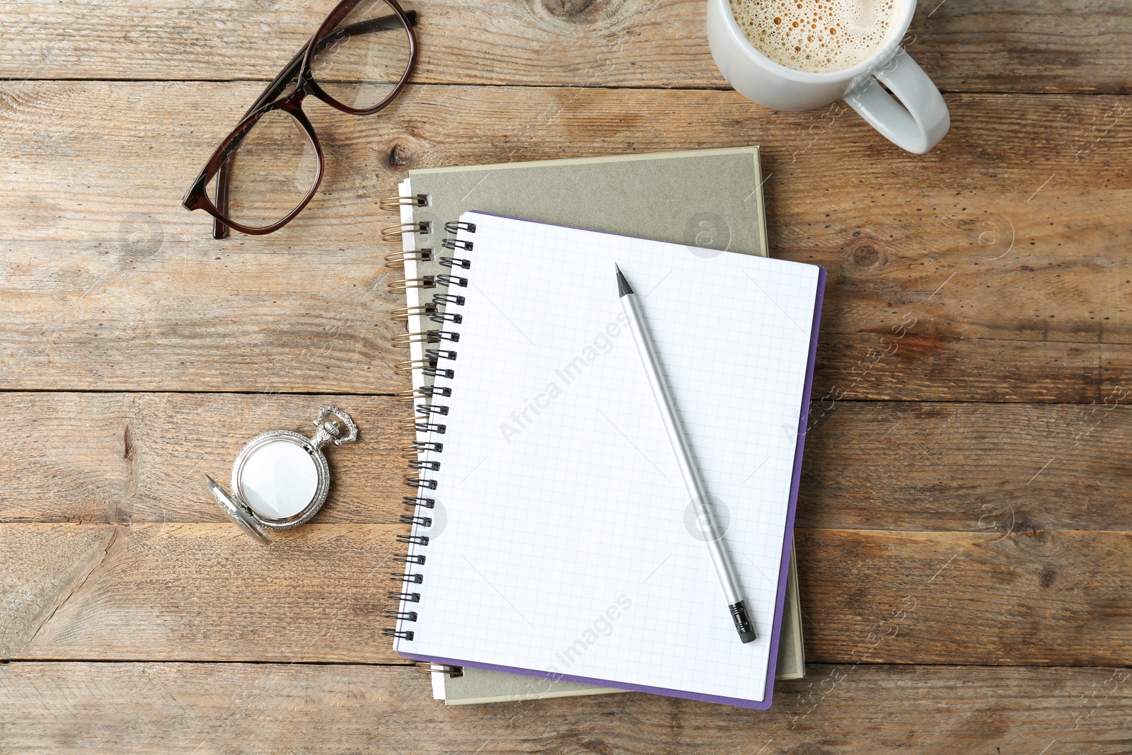 Photo of Flat lay composition with office stationery and cup of coffee on wooden table