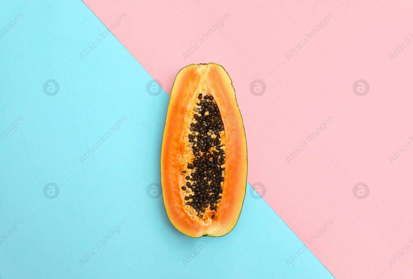 Photo of Fresh juicy halved papaya on color background, top view. Space for text