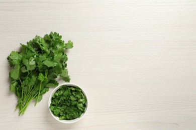 Photo of Fresh green cilantro on white wooden table, flat lay. Space for text