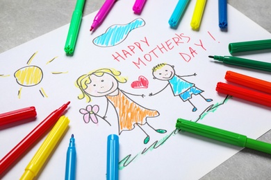 Photo of Handmade greeting card for Mother's Day and felt tip pens on grey table, closeup