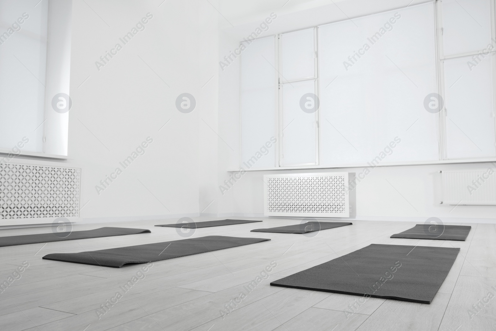 Photo of Spacious yoga studio with exercise mats and big windows, low angle view