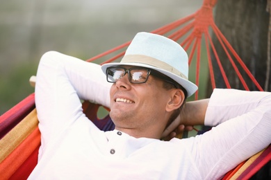 Man resting in comfortable hammock at green garden