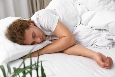 Photo of Handsome young man sleeping on pillow at home. Bedtime