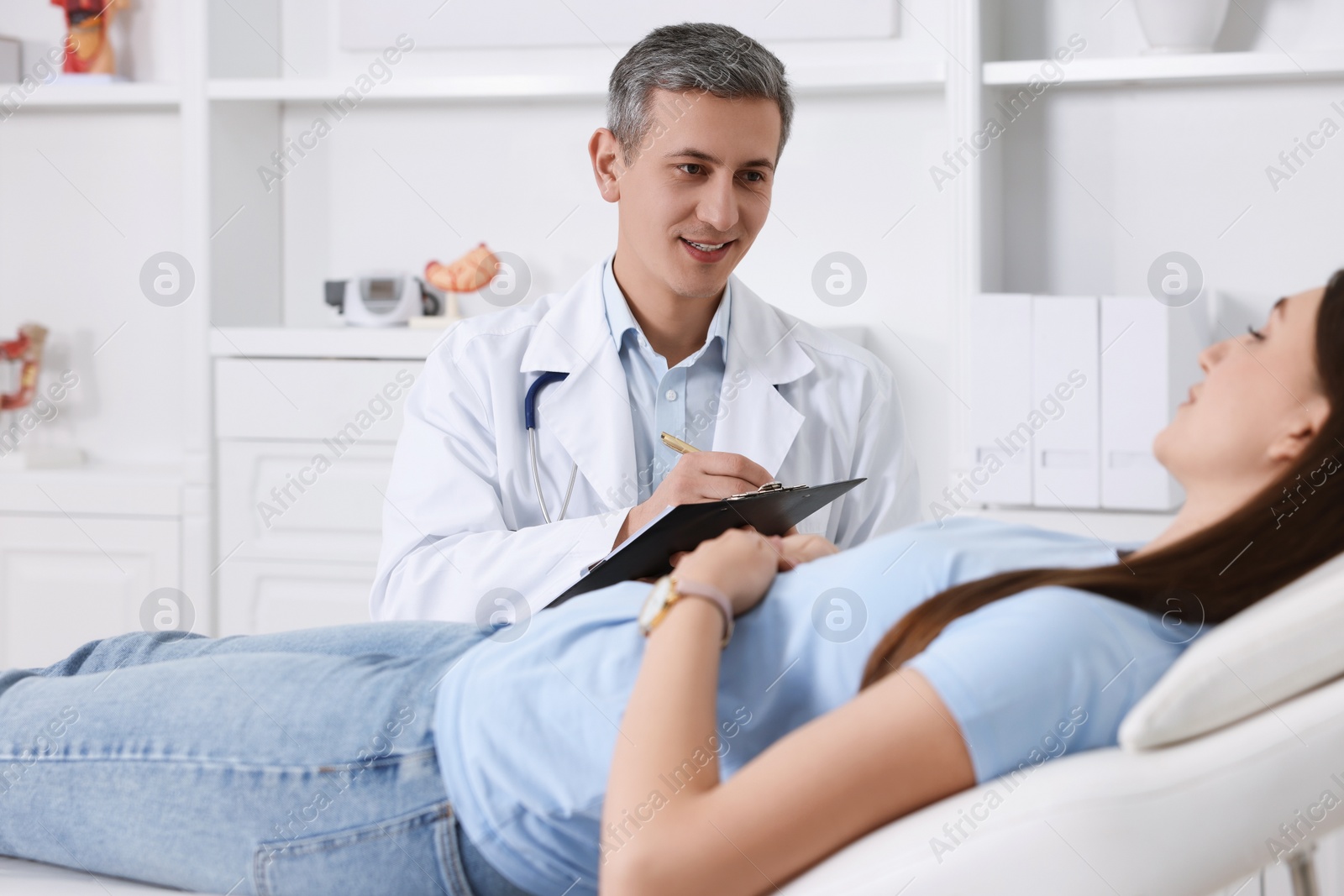 Photo of Gastroenterologist with clipboard consulting patient in clinic