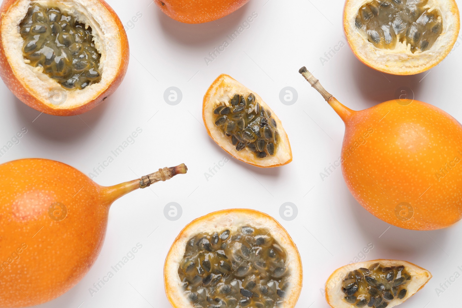 Photo of Delicious ripe granadillas on white background, flat lay