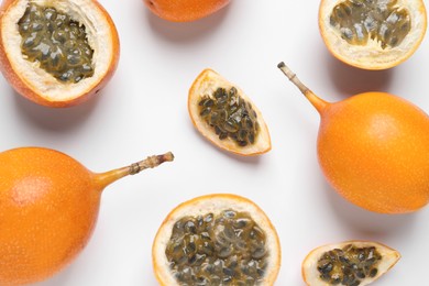 Photo of Delicious ripe granadillas on white background, flat lay