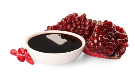 Photo of Bowl of pomegranate sauce and fresh ripe fruit on white background