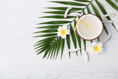 Photo of Flat lay composition with half of coconut on white wooden background. Space for text