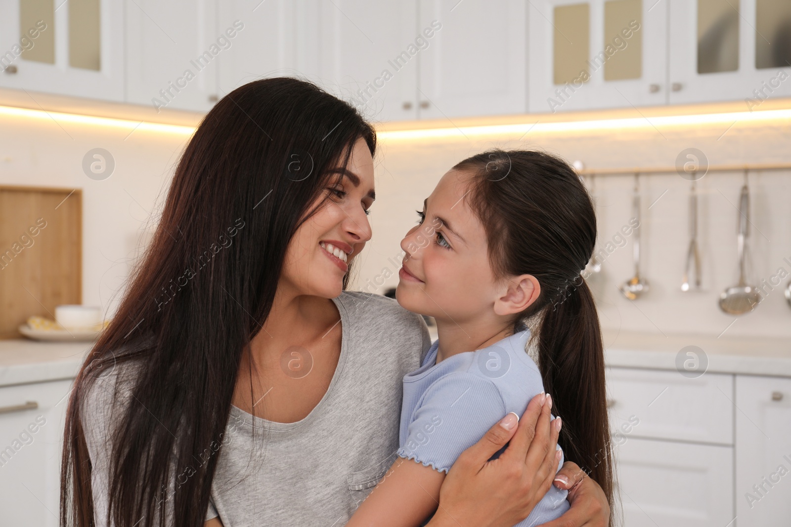 Photo of Happy mother and daughter hugging in kitchen. Single parenting