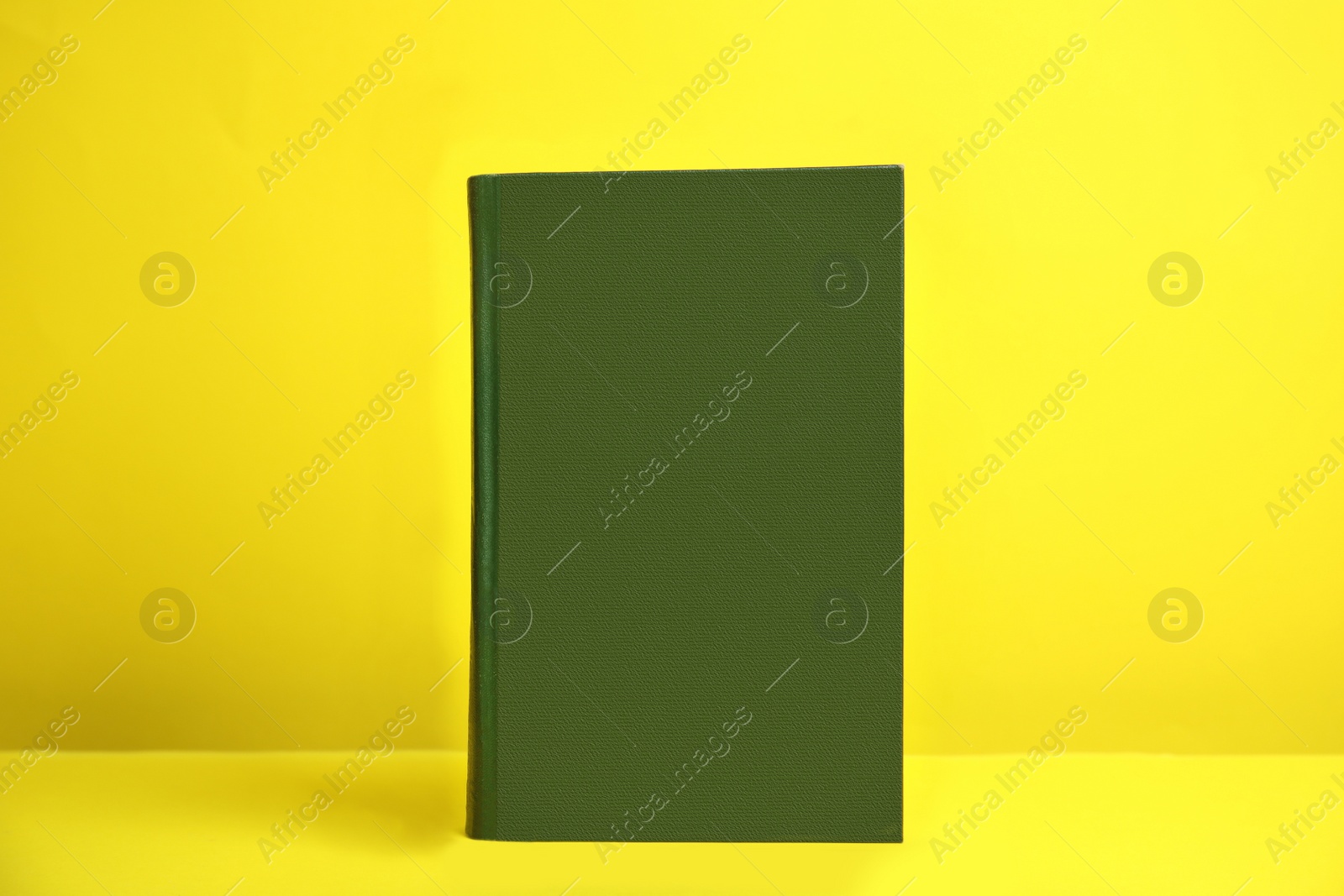 Photo of Hardcover book on yellow background. Space for design