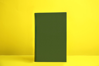 Photo of Hardcover book on yellow background. Space for design