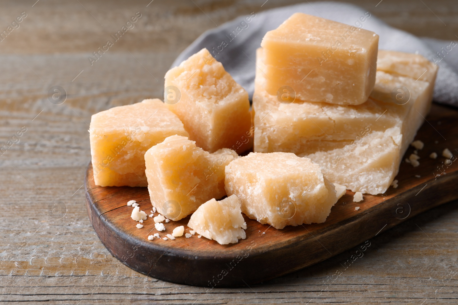 Photo of Pieces of delicious parmesan cheese on wooden table, closeup