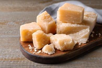 Pieces of delicious parmesan cheese on wooden table, closeup