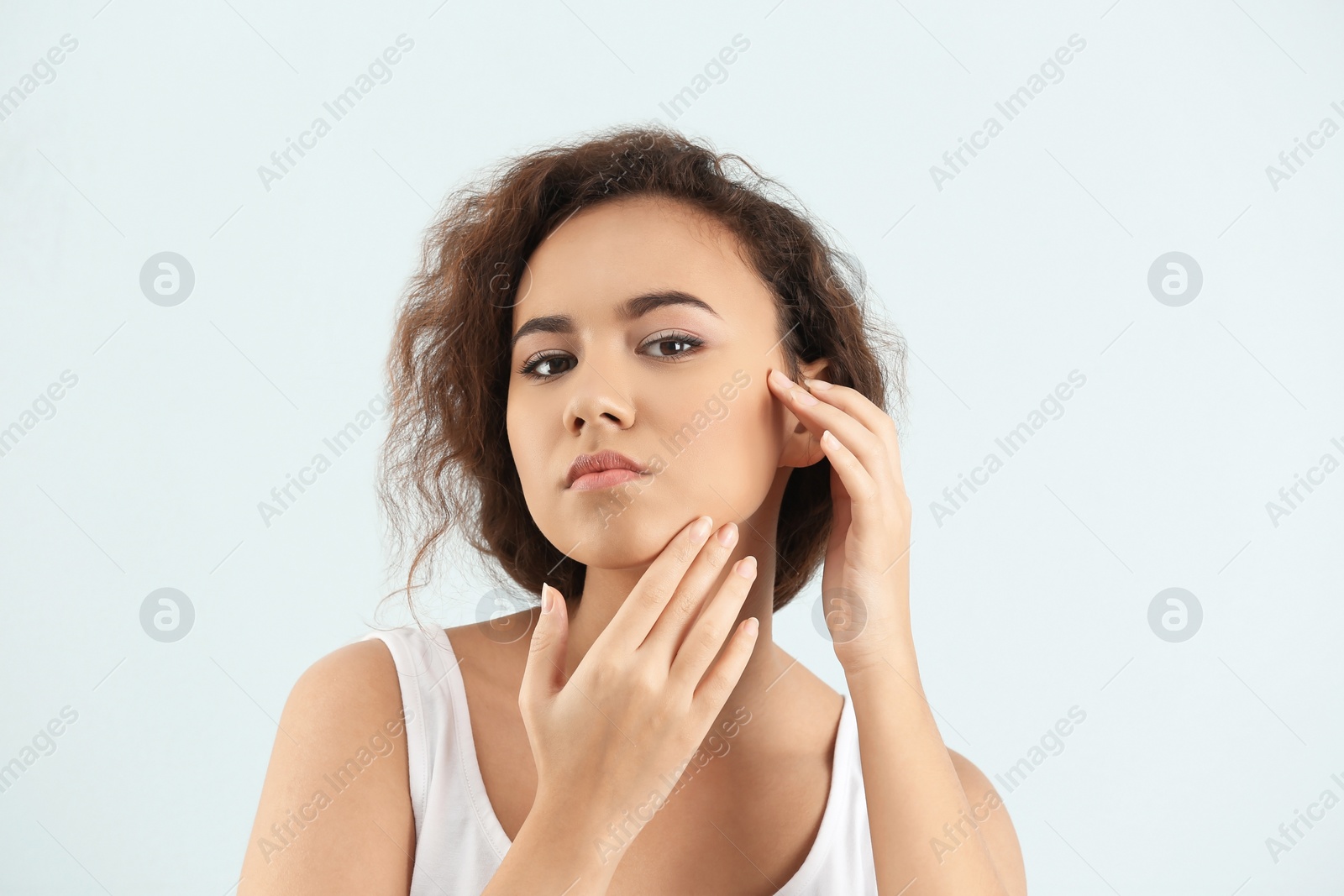 Photo of Beautiful young woman with acne problem on light background