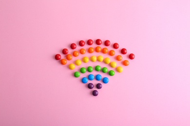 Colorful glazed candies on pink background, flat lay