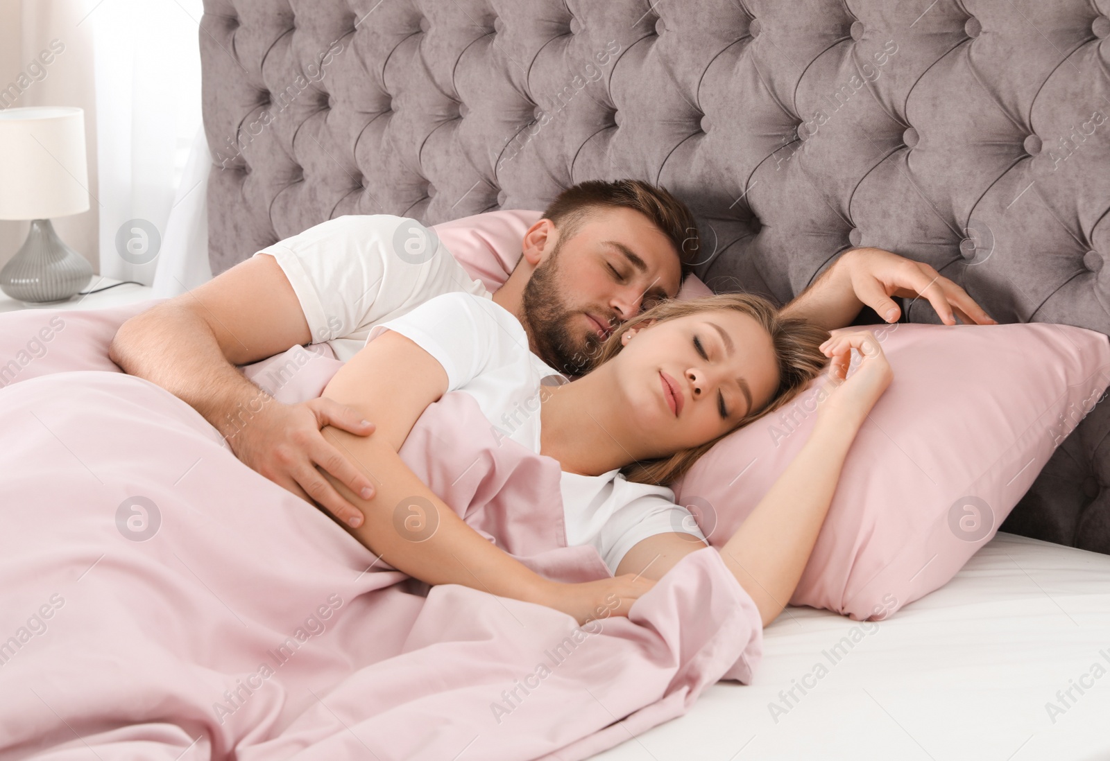 Photo of Young couple sleeping together in bed at home