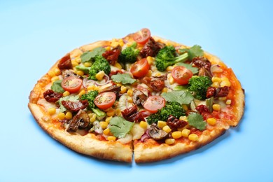 Photo of Delicious vegetarian pizza with mushrooms, vegetables and parsley on light blue background