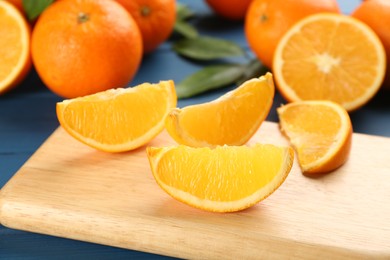 Photo of Slices of delicious ripe oranges on wooden board, closeup