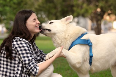 Photo of Teenage girl with her white Swiss Shepherd dog in park