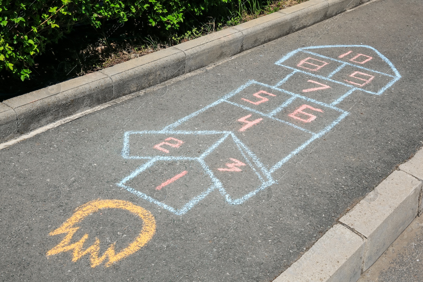 Photo of Hopscotch drawn with colorful chalk on asphalt outdoors