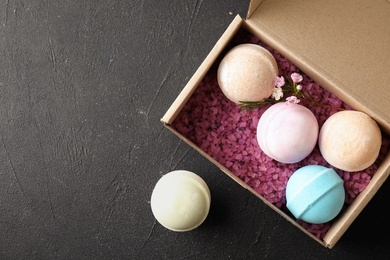 Carton box with bath bombs and space for text on black background, top view