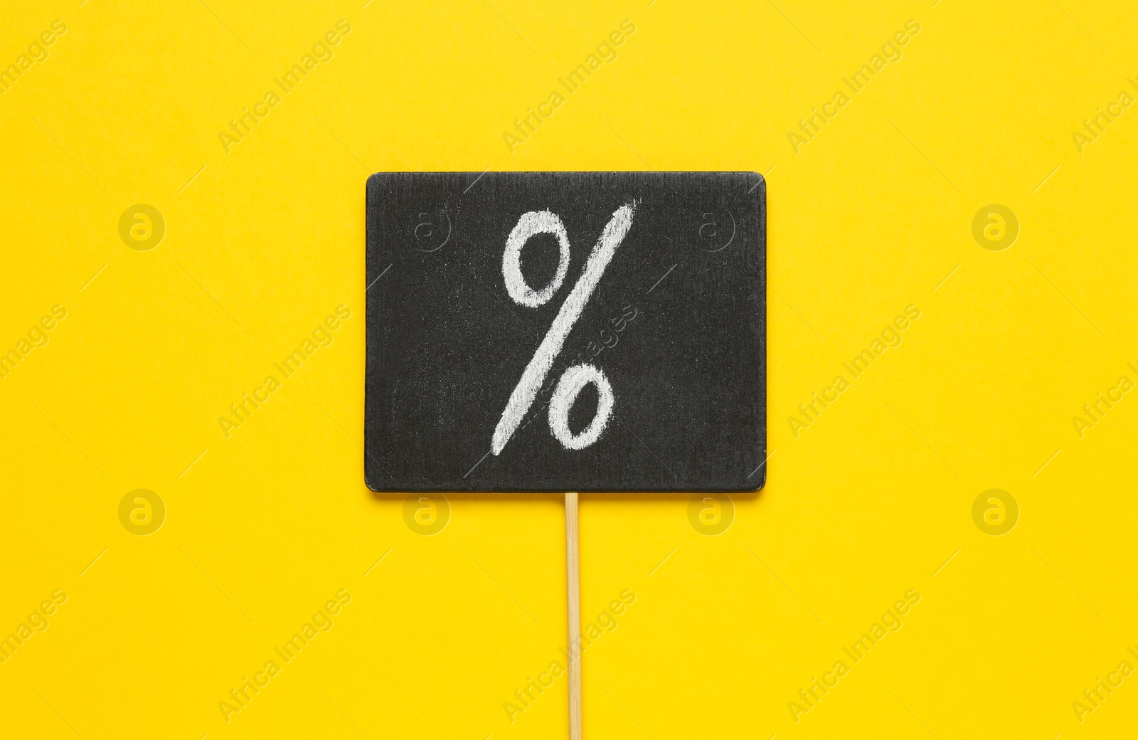 Photo of Sign with percent symbol on yellow background, top view