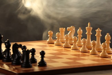 Photo of Chessboard with game pieces on grey background