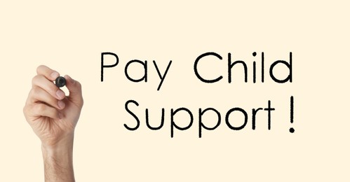 Man with marker and phrase PAY CHILD SUPPORT! on beige background, closeup. Banner design