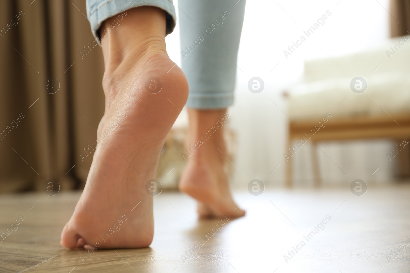 Photo of Woman walking barefoot at home, space for text. Floor heating concept