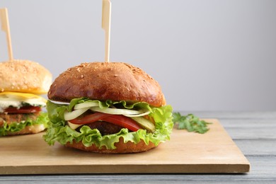 Photo of Delicious vegetarian burgers served on grey wooden table