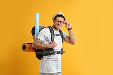 Photo of Male tourist with travel backpack on yellow background