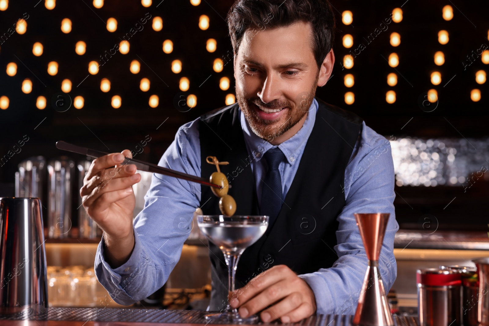 Photo of Bartender preparing fresh alcoholic cocktail in bar