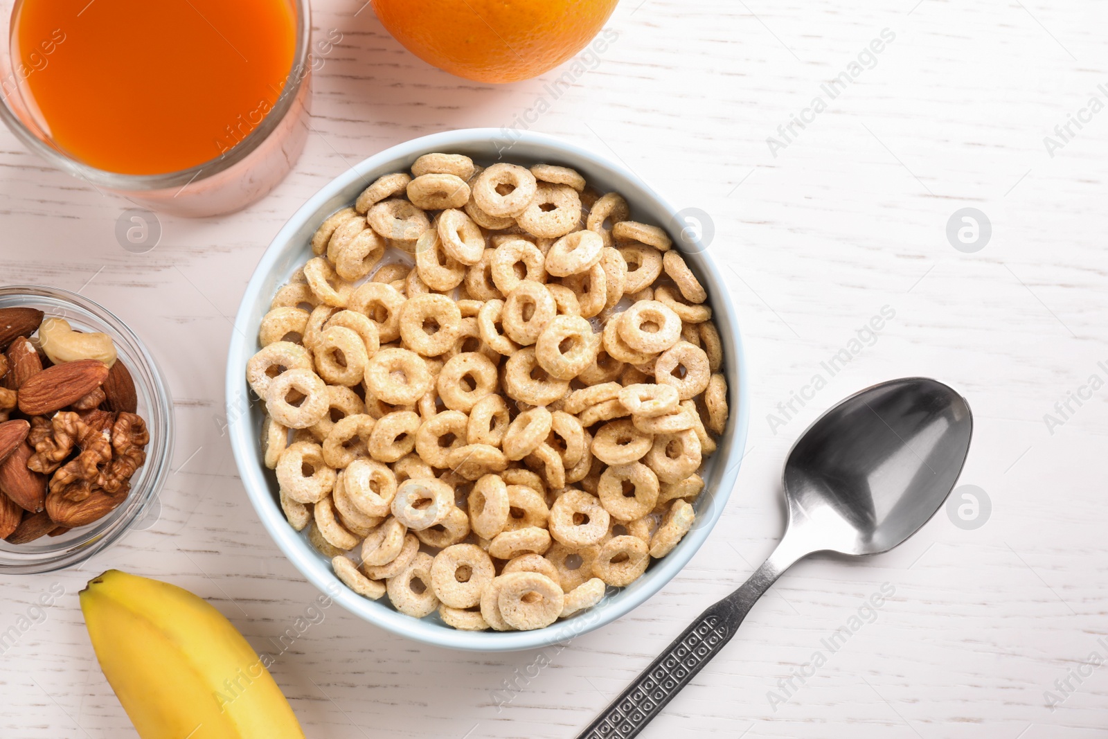 Photo of Flat lay composition with corn rings on white wooden table. Healthy breakfast
