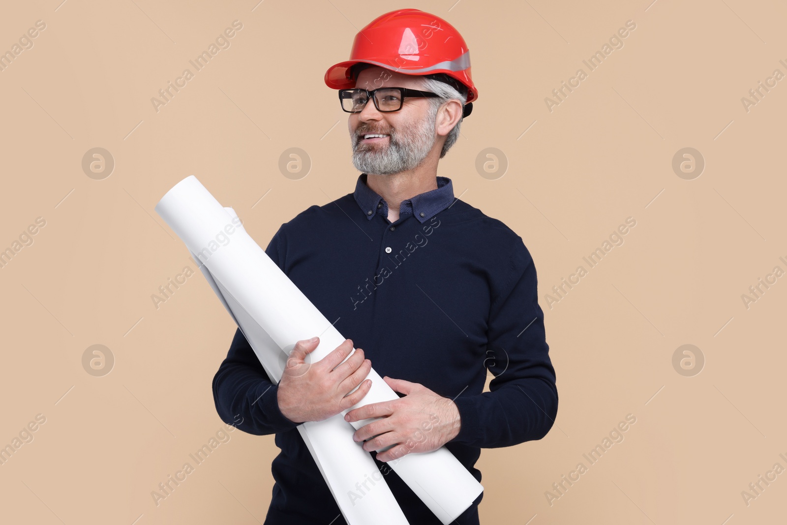 Photo of Architect in hard hat holding drafts on beige background