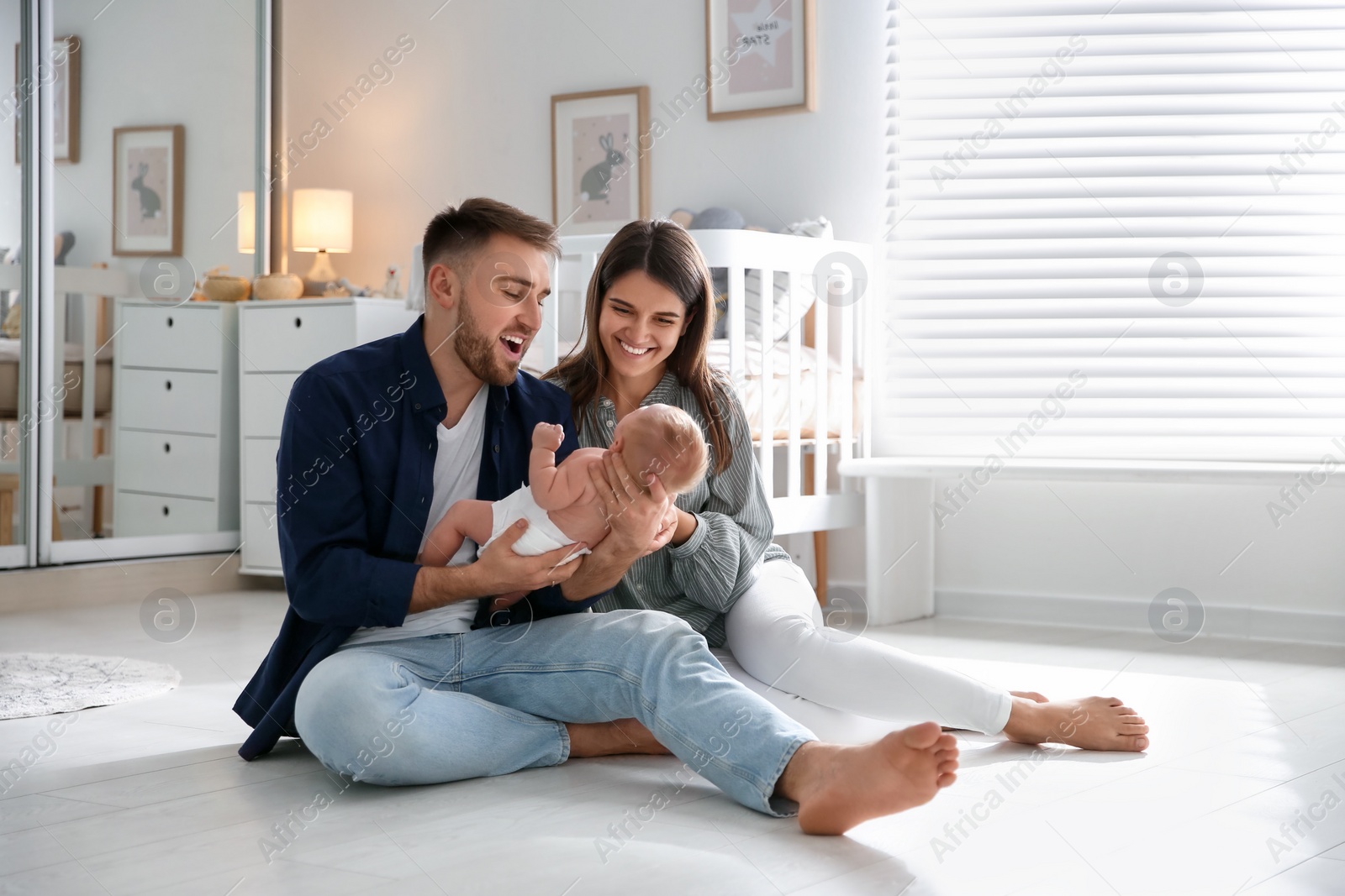 Photo of Happy couple with their newborn baby at home