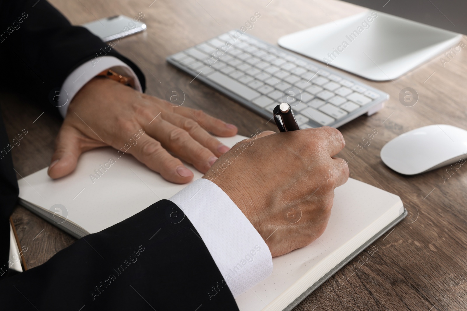 Photo of Boss working at wooden table indoors, closeup