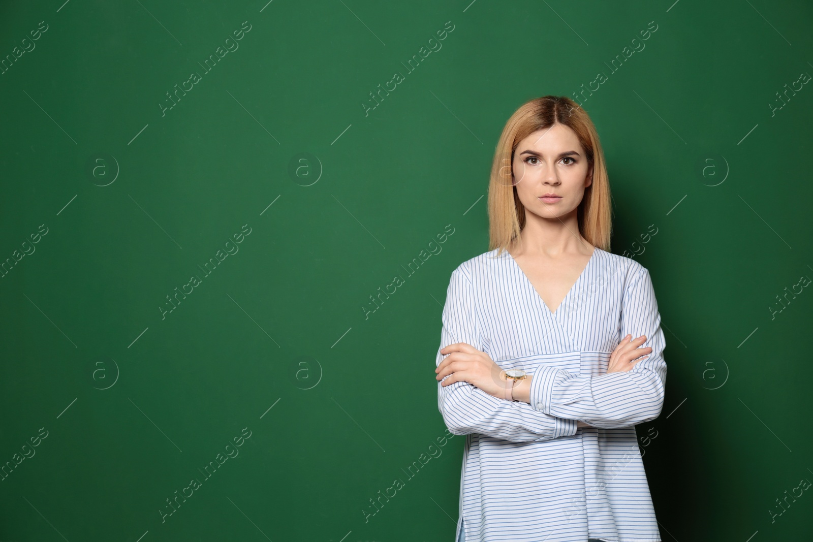 Photo of Portrait of beautiful teacher near chalkboard, space for text
