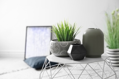 Photo of Beautiful vases and houseplant on table indoors. Idea for interior decor