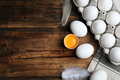 Photo of Flat lay composition with fresh raw chicken eggs on wooden table. Space for text