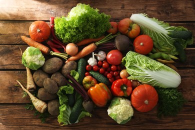 Different fresh ripe vegetables on wooden table, flat lay. Farmer produce