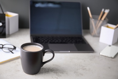 Photo of Black cup with coffee on office table. Space for text