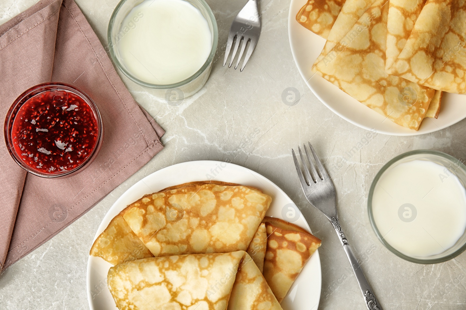 Photo of Flat lay composition with fresh thin pancakes on light grey marble table
