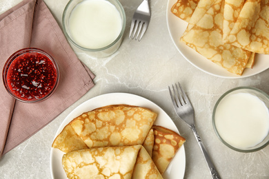 Flat lay composition with fresh thin pancakes on light grey marble table