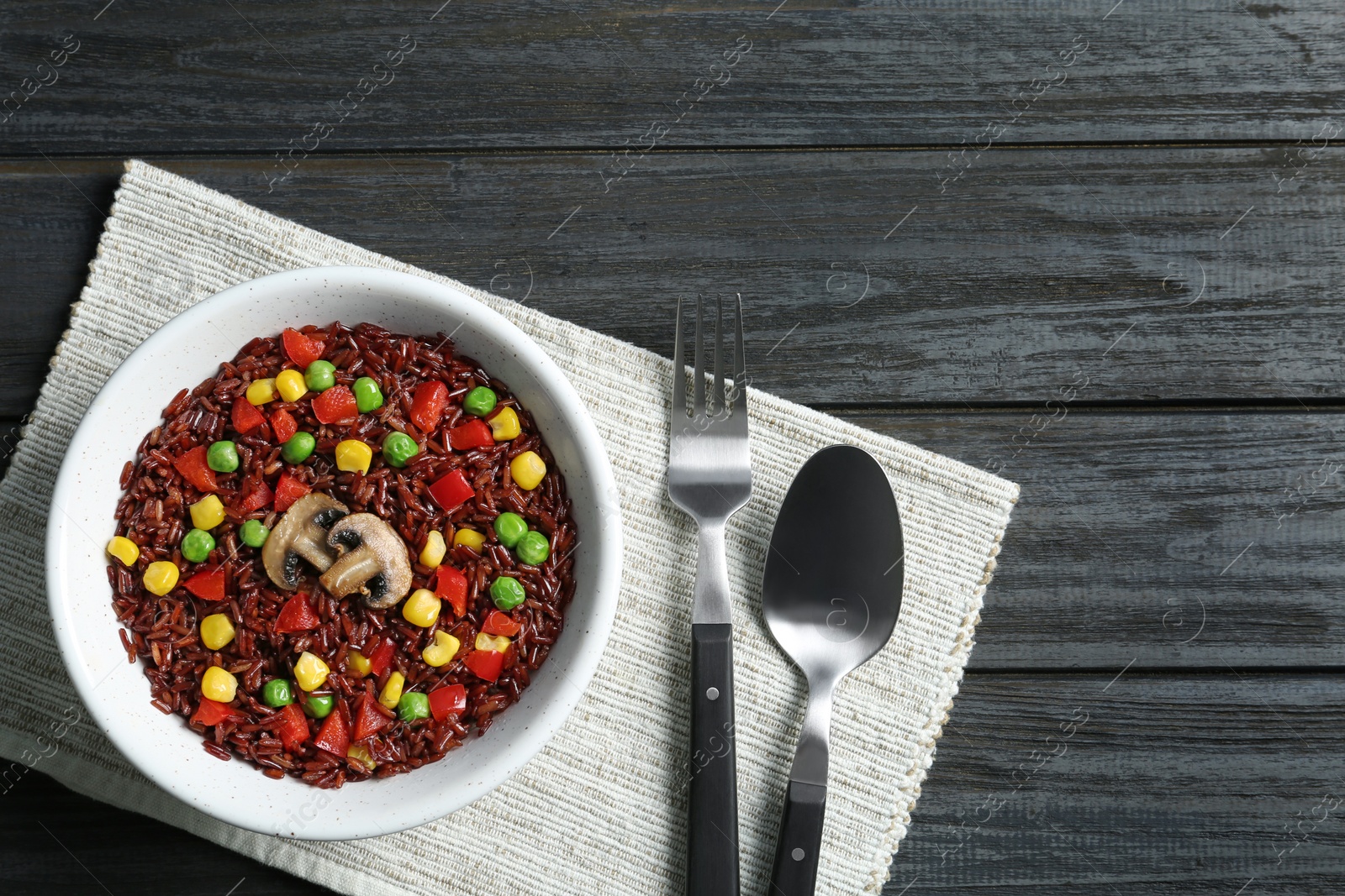 Photo of Bowl with cooked brown rice served on table, top view. Space for text