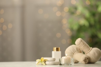 Photo of Composition with herbal bags and burning candle on white table against blurred festive lights, space for text